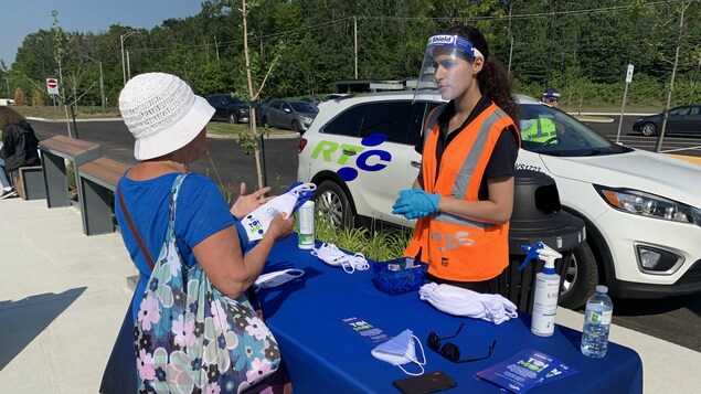 Une employée du RTC distribue des masques