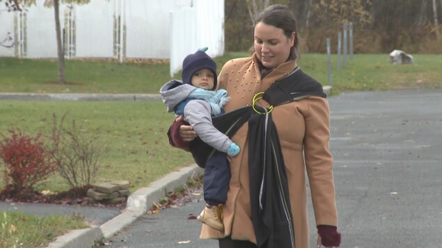 Une Drummondvilloise porte son enfant dans un porte-bébé en tissus.