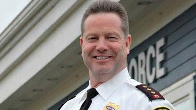 Jeff Porter souriant devant le poste de police.