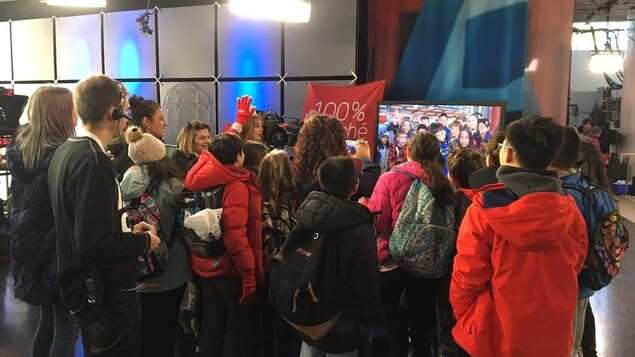 Des enfants se voient dans  un écran.
