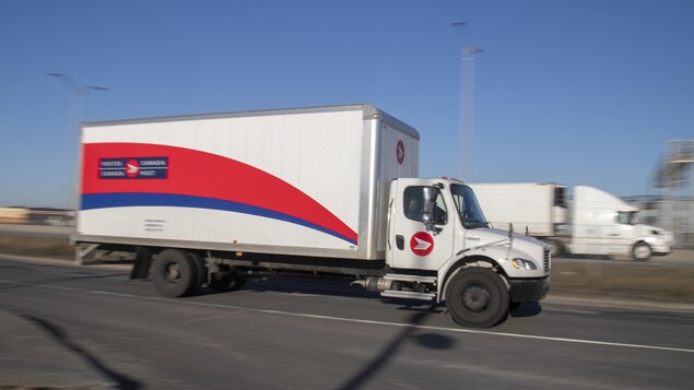 Un camion de Postes Canada circule sur l'autoroute.