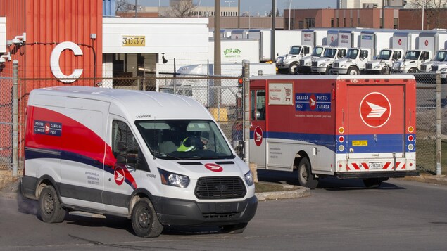 Des camions de livraison de Postes Canada sont stationnés.