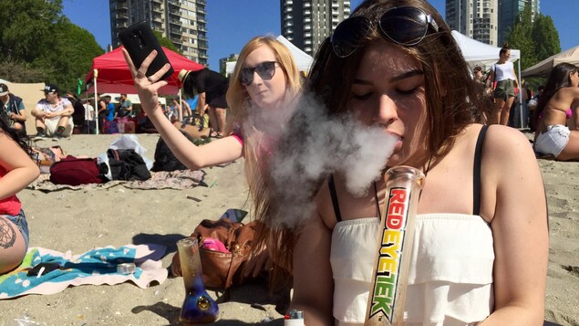 Une jeune femme fume de la marijuana sur la plage. Une jeune femme fume de la marijuana sur la plage.