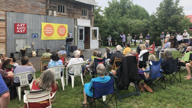 De nombreuses personnes sont assises devant un vieux batiment