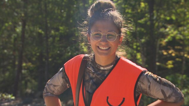 Sandrine, souriante, porte une veste de chasse orange. Sandrine, souriante, porte une veste de chasse orange.