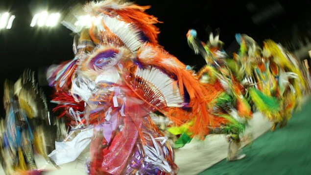 Des danseurs de pow-wow portent des plumes.