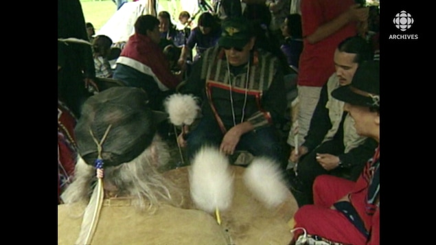 Men who all beat on a big drum.