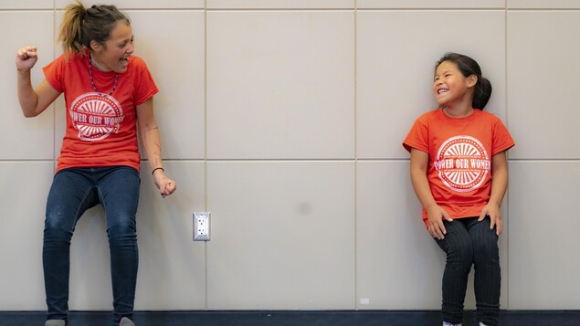 Deux jeunes filles lors d'un exercice contre le mur rigolent en se regardant. Deux jeunes filles lors d'un exercice contre le mur rigolent en se regardant.