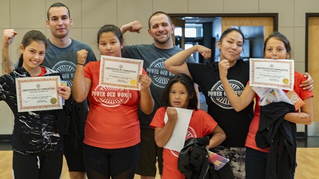 Un groupe de quatre jeune filles et une jeune femme et deux hommes posent avec des certificats en brandissant le poing. Un groupe de quatre jeune filles et une jeune femme et deux hommes posent avec des certificats en brandissant le poing.