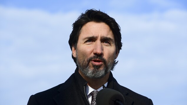 Justin Trudeau parle sous un ciel bleu.