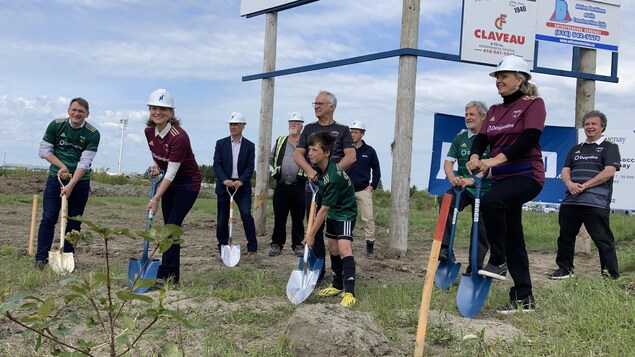La mairesse de Saguenay, Josée Néron, le député de Jonquière Sylvain Gaudreault, la ministre Andrée Laforest et des conseillers posent avec des pelles.