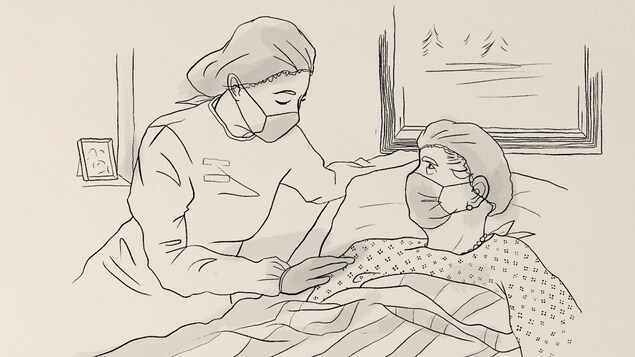 Une femme portant un masque de protection réconforte un patient portant lui aussi un masque de protection, couché dans son lit