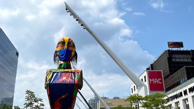 Una de las marionetas gigantes observa el recinto del festival lleva una mascarilla cubreboca. 
