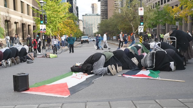 Personas rezan en la calle.