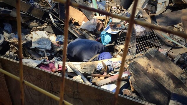 Une homme fouille dans une pile de décombres. Une homme fouille dans une pile de décombres.