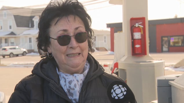 Une femme à la pompe d'une station-service en entrevue.
