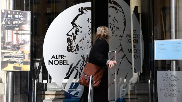 Une femme ouvre la porte du musée Alfred Nobel, à Stockholm, en Suède, situé dans le même bâtiment que le siège de l'Académie suédoise, où sera remis le prix Nobel de littérature 2020.