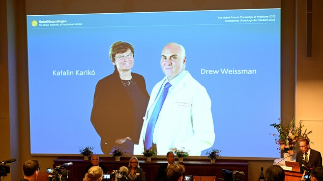 Katalin Kariko of Hungary, left, and Drew Weissman of the United States, right, are shown on a projected screen at the Karolinska Institute in Stockholm on Monday during the announcement of the winners of the 2023 Nobel Prize in Physiology or Medicine. 