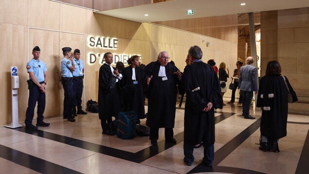 Des gendarmes français et des avocats dans un tribunal.
