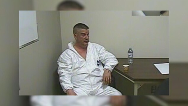 Pascal Gagnon vêtu d'un habit blanc de prisonnier.