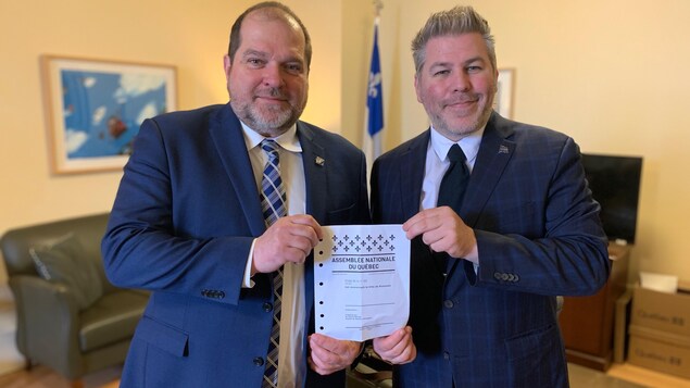 Le député de Rimouski, Harold LeBel, et le député de Matane-Matapédia, Pascal Bérubé, avec le projet de loi privé 202 sur La Grande Place de Rimouski.