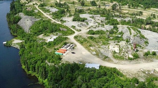 Vue aérienne d’une installation d’exploration minière en forêt près d’un lac.