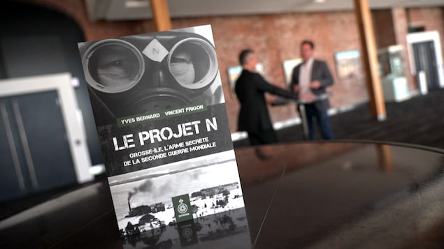 Une couverture d'un livre devant deux hommes qui discutent. 