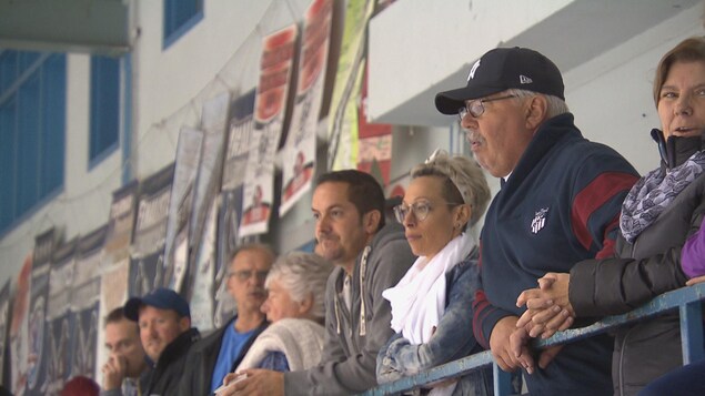Des parents regardent leur enfant disputer un match de hockey. Des parents regardent leur enfant disputer un match de hockey.