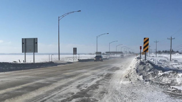 Une voiture sur une route en hiver.
