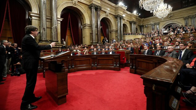 Carles Puigdemont debout face aux élus catalans assis Carles Puigdemont debout face aux élus catalans assis