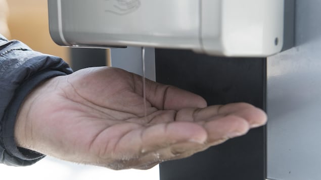 Un homme utilise une solution hydroalcoolique pour se laver les mains.