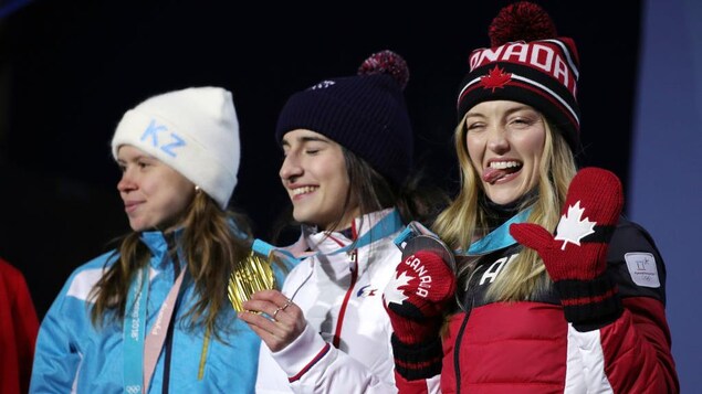 Plan moyen des trois athlètes sur le podium. Plan moyen des trois athlètes sur le podium.