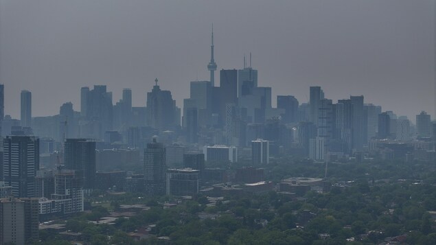 Le centre-ville de Toronto, vu de l'est, couvert d'un épais nuage de fumée grise.