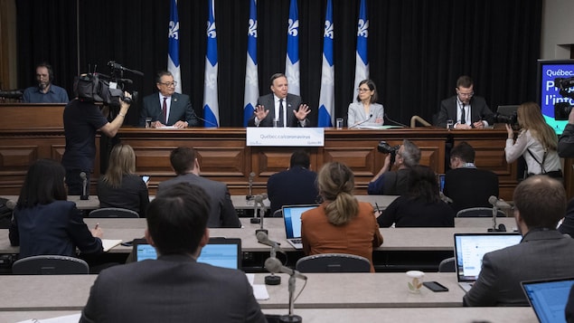 Des journalistes et photographes sont installés devant la table où sont assis les autorités compétentes.