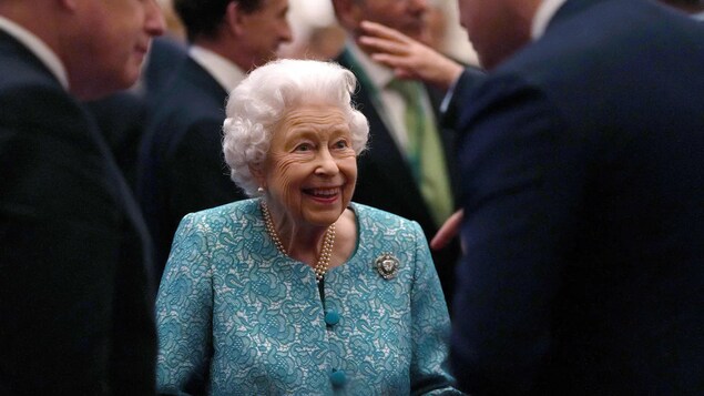 Napapaligiran si Queen Elizabeth ng mga kalalakihan.