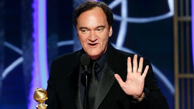Un homme en complet donne un discours de remerciements.