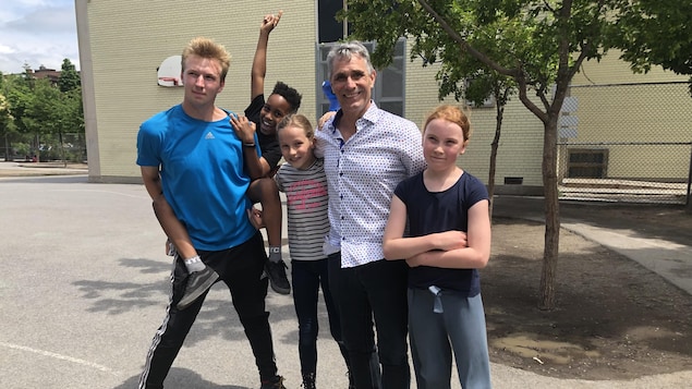 Quentin Tison et d'autres personnes à l'extérieur d'une école.