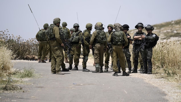 Des soldats dans un chemin de campagne.