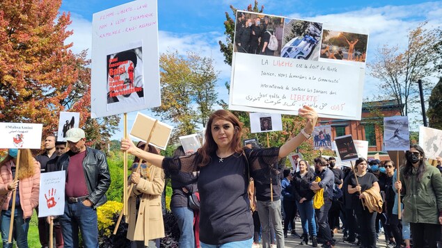 Une femme tient des affiches lors du rassemblement. 