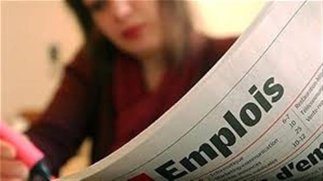 امرأة تتصفح إعلانات عن الوظائف في جريدة.
