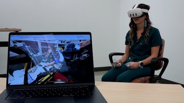 Une étudiante porte un casque de réalité virtuelle avec un ordinateur posé devant elle dans lequel on voit le scénario.