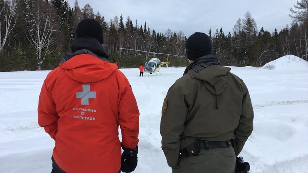Deux hommes regardent un hélicoptère.