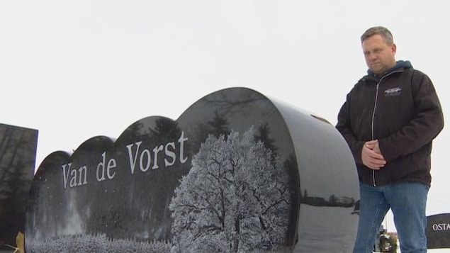 Chad Mierau se tient devant la pierre tombale de la famille Van de Vorst. 
