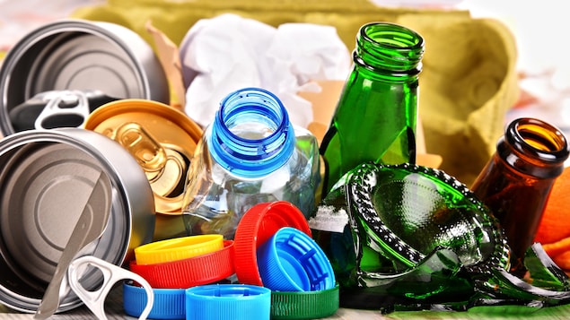 Des objets faits de matières recyclables : boîtes de conserve en métal, bouteilles de verre, bouchons de plastique.