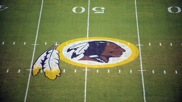 Un terrain de football où le logo des Redskins représentant un Autochtone et des plumes a été peint.