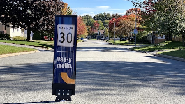 Une affiche sur laquelle est inscrite l'expression "Vas-y mollo", accompagnée d'une limite de vitesse fixée à 30 km/h.