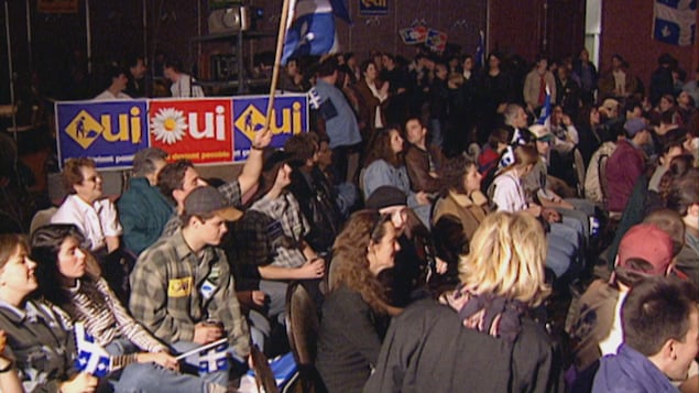 Une salle bondée de jeunes partisans joyeux.