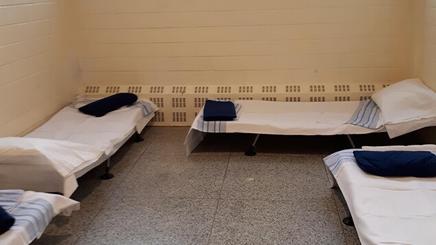 Quatre lits de camp dans une pièce Quatre lits de camp dans une pièce