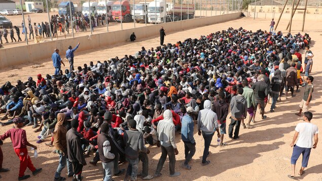 Des centaines d'hommes sont assis par terre. Des centaines d'hommes sont assis par terre.