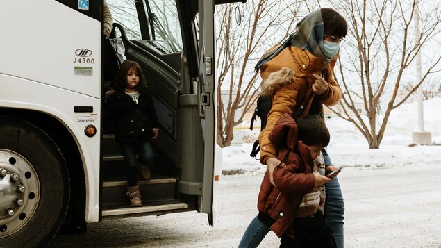 Une femme afghane et son enfant viennent de descendre d'un autocar à Edmonton.